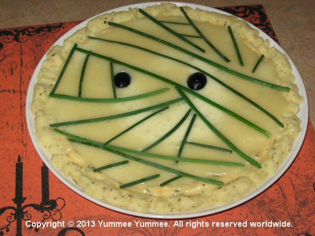 Make a mummy pizza - gluten-free with chives, black olives, white sauce, and white cheese. Yummee!