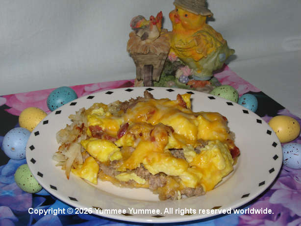 Breakfast menu - eggs, bacon, sausage, cheese & hash browns in a pizza.